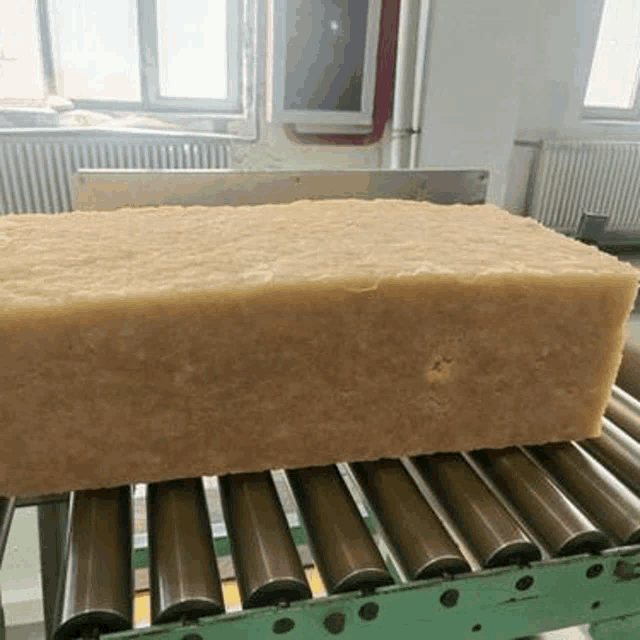 a large piece of soap is sitting on a conveyor belt in a factory .