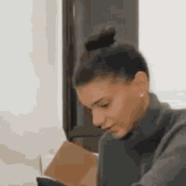a woman is reading a book while sitting on a couch