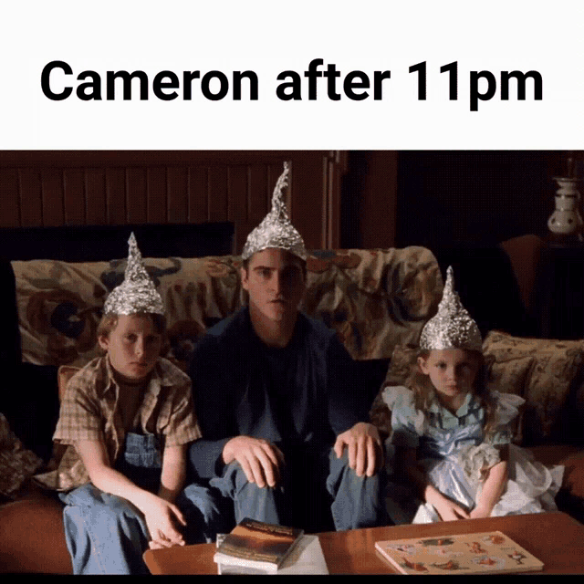 a man and two children wearing aluminum foil hats sit on a couch with the caption cameron after 11 pm