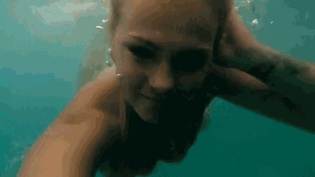 a woman in a bikini is swimming underwater in the ocean