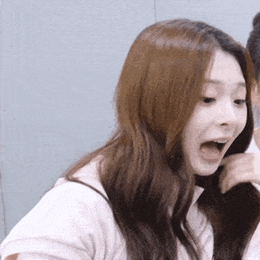 a woman with a surprised look on her face is wearing a white shirt