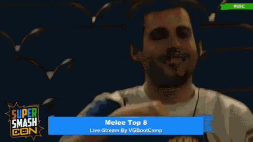 a man covering his face with his hand while watching a super smash con event