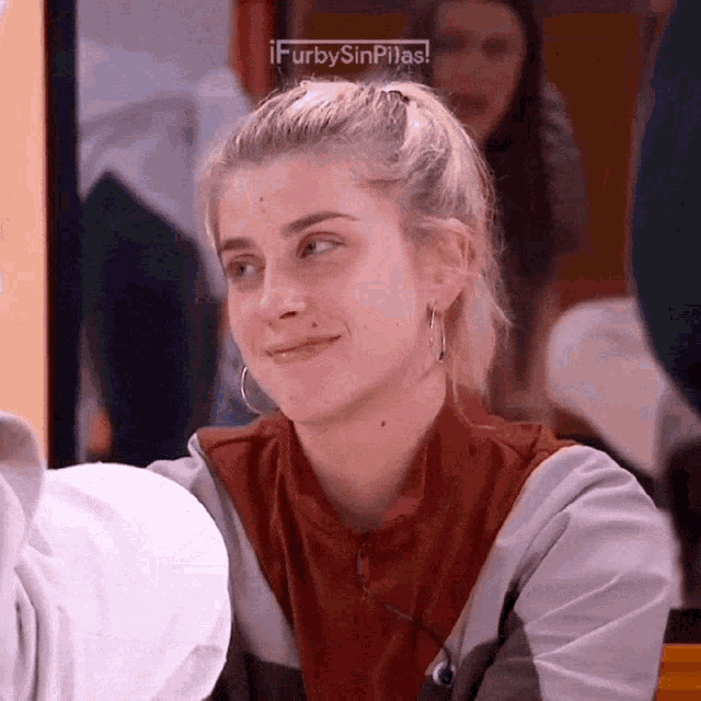 a woman with a ponytail is smiling in front of a screen that says furbysinpilas