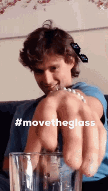 a man is holding a glass with the hashtag #movetheglass on it