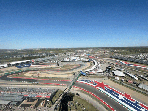 an aerial view of a race track with a red white and blue flag on the side