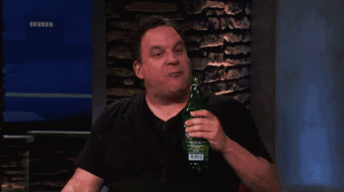 a man in a black shirt is holding a green bottle with a label that says ' sprite ' on it