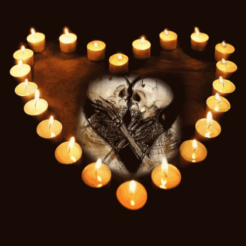 candles are arranged in the shape of a heart with two skeletons kissing in the center