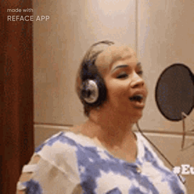 a woman is wearing headphones and singing into a microphone .