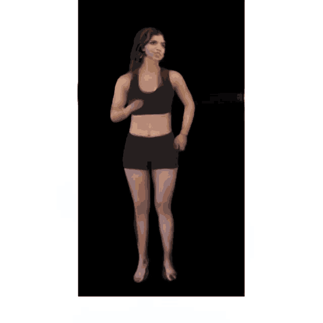a woman in a black tank top and black shorts is dancing .