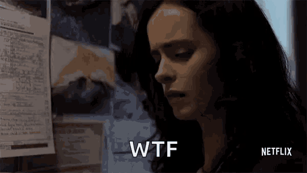 a woman is standing in front of a wall with papers on it and says wtf on it .