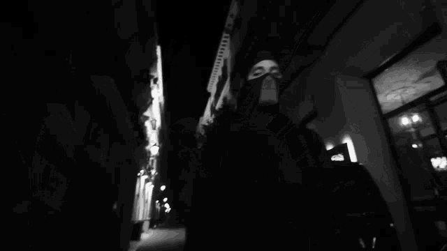 a black and white photo of a man wearing a mask and a license plate which says a141 wkc