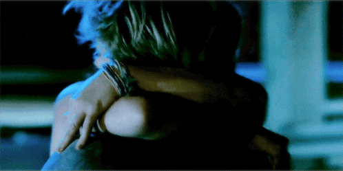 a man and a woman are hugging in the dark