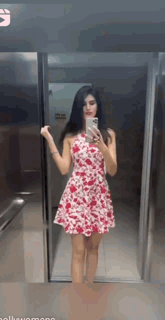 a woman in a red and white dress is taking a selfie
