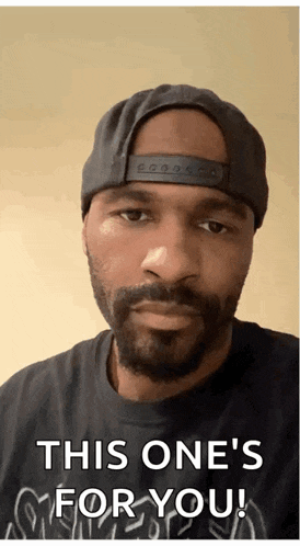 a man with a beard wearing a hat and a black shirt says " this one 's for you "