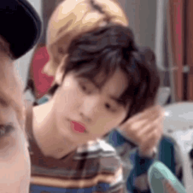 a close up of a person applying makeup to another person 's face in front of a mirror .