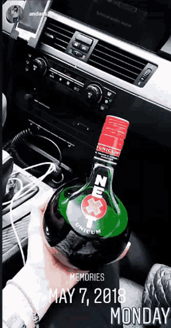 a person is holding a bottle of next unicum