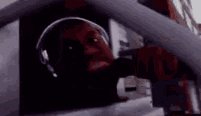 a man is wearing headphones and making a funny face .