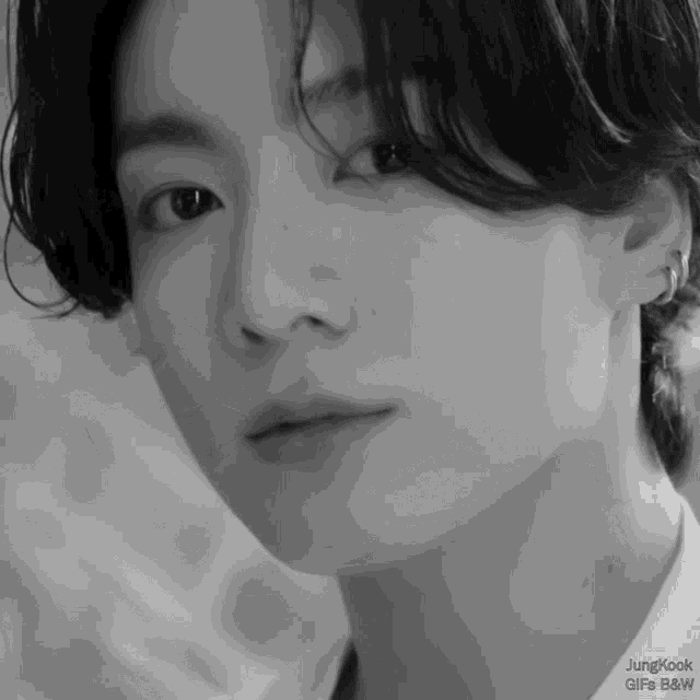 a close up of a young man 's face with the words jungkook gifs b & w on the bottom
