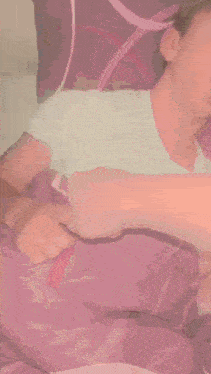 a young man is laying in bed with a purple blanket