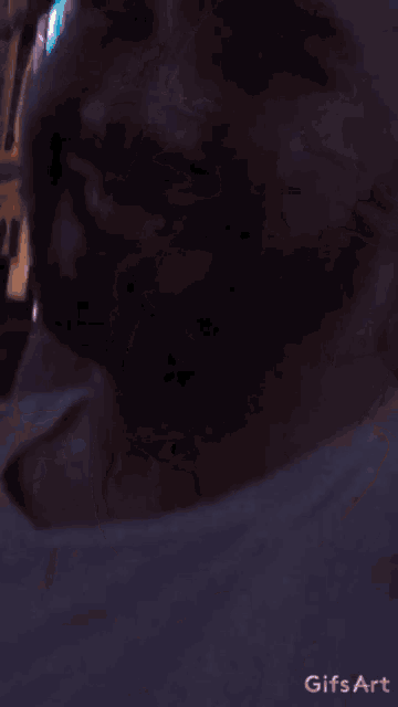 a man with a beard is sitting in a room with a gifs art watermark