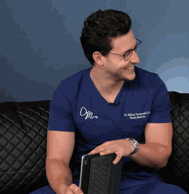 a man wearing glasses and a blue scrub top that says dr. mikhail yashchenko family medicine
