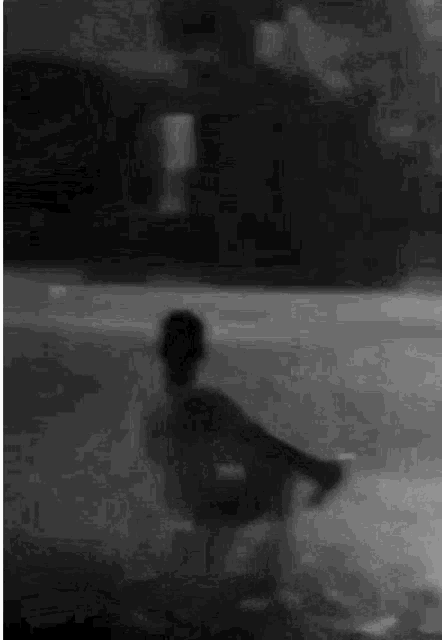 a black and white photo of a person standing in a pool .