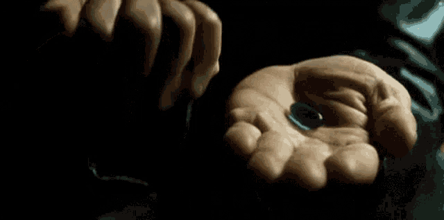 a person is holding a skull and a blue pill