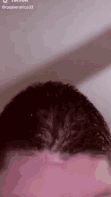 a close up of a person 's hair with a pink background