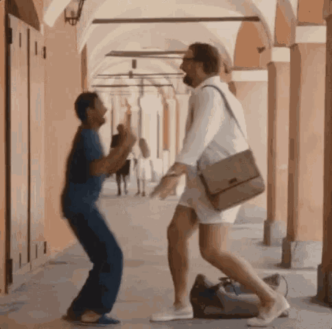 a man and a woman are dancing together on a sidewalk .
