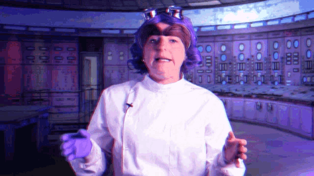 a woman in a lab coat and purple wig is standing in front of a control room