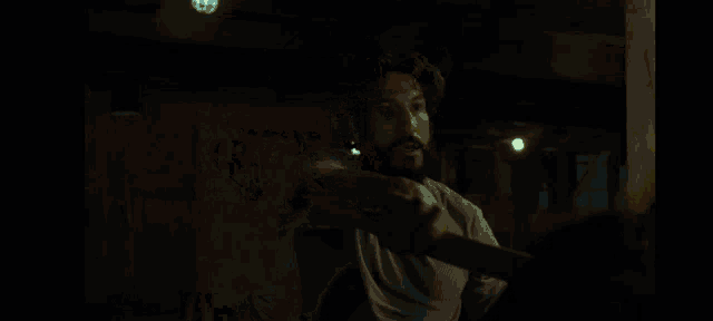 a man with blood on his face is laying down in a dark room