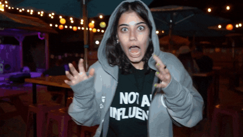 a woman wearing a hoodie and a shirt that says not a influence