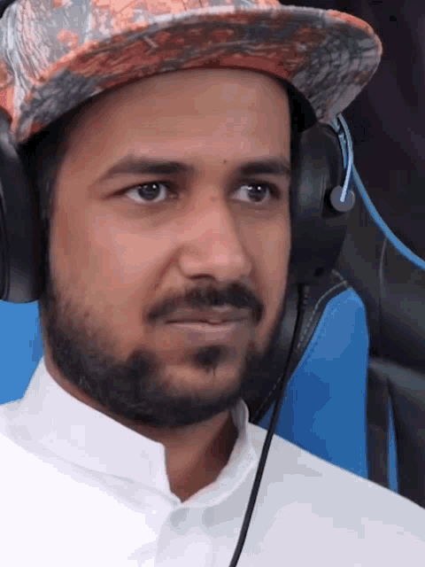 a man wearing headphones and a hat is making a funny face