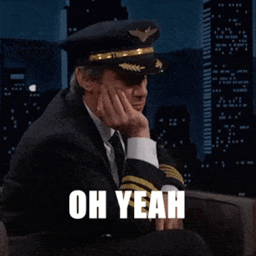 a man in a suit and tie wearing a pilot 's hat