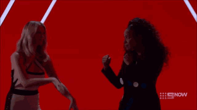 a woman kicking another woman on a blue background with the number 9 now