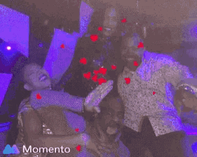 a man and woman are dancing in a dark room with a momento logo on the bottom