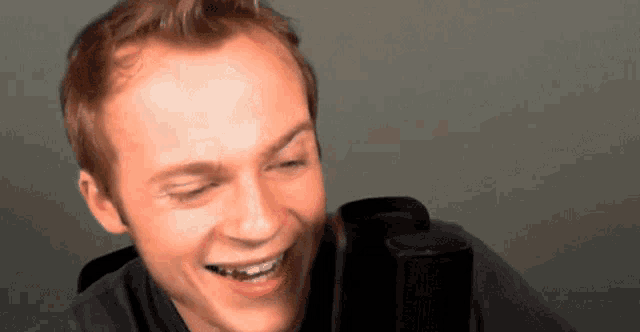 a close up of a man 's face with a microphone in the background