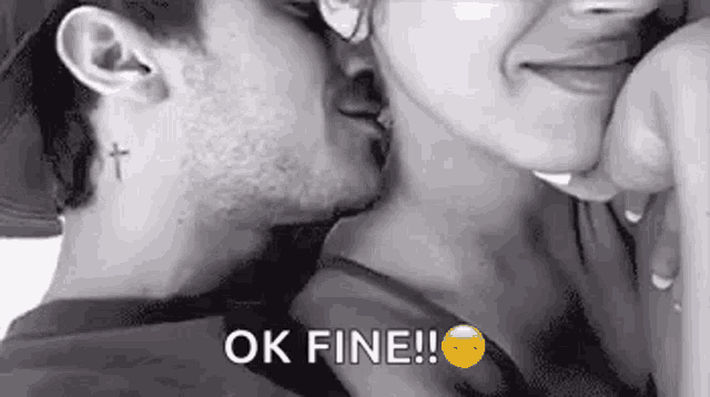 a man is kissing a woman on the neck .