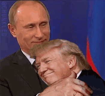 a man in a suit and tie is hugging another man in a suit
