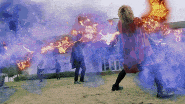 a woman in a red cape is surrounded by flames and purple smoke