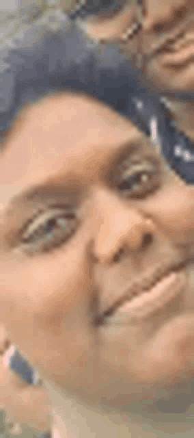 a close up of a woman 's face with a man behind her .