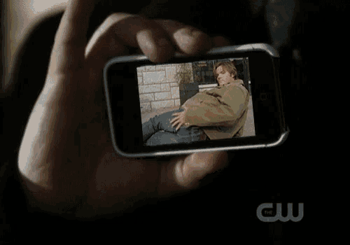 a person is holding a cellphone with a picture of a man on it