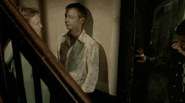 a man standing next to a door with a man laying on the floor