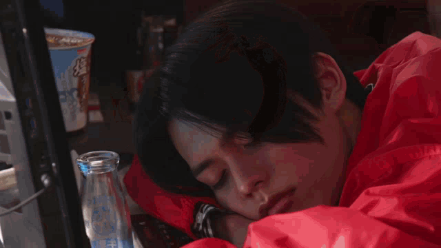 a woman is laying on a bed with her eyes closed and a sign in the background that says cc