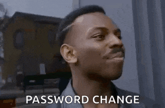 a man is smiling and saying `` password change '' while standing in front of a window .
