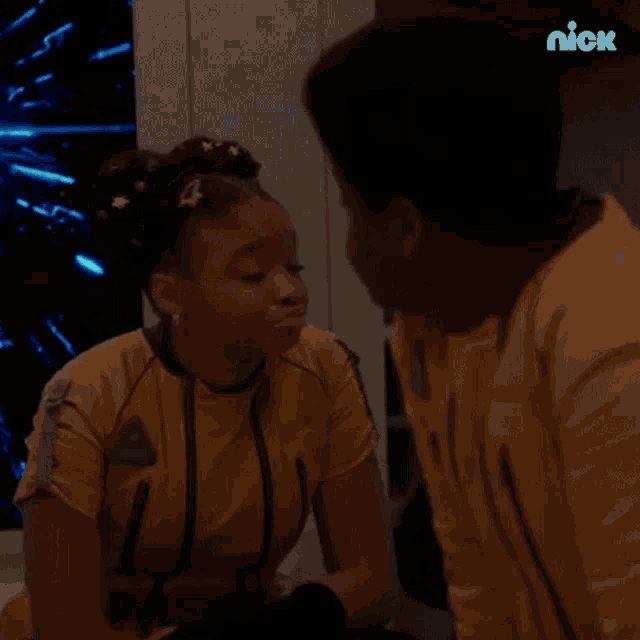 a man and a woman are sitting next to each other in a room and making funny faces .