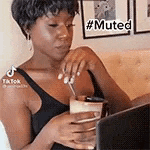a woman is sitting on a couch holding a glass of water .