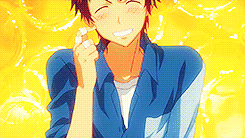 a man in a blue shirt is smiling with a yellow background behind him .