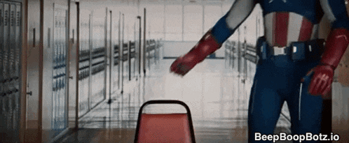 a man in a captain america costume is standing in a hallway next to a red chair .