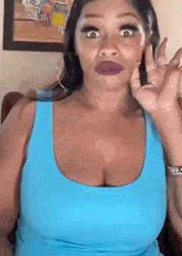 a woman in a blue tank top is talking on a cell phone .